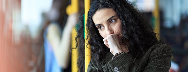 kvinna som står på en buss och ser fundersam ut